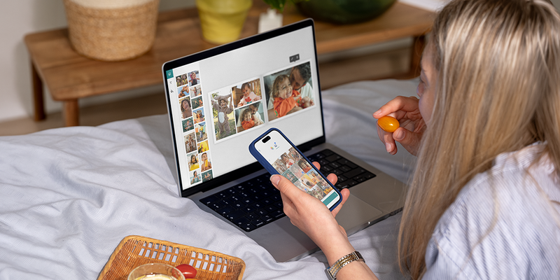 Een vrouw gebruikt de albelli desktop editor op haar laptop terwijl ze een cherrytomaat eet om een gepersonaliseerd fotoboek te maken, als inspiratie voor een makkelijk fotoboek maken en een fotoalbum maker.