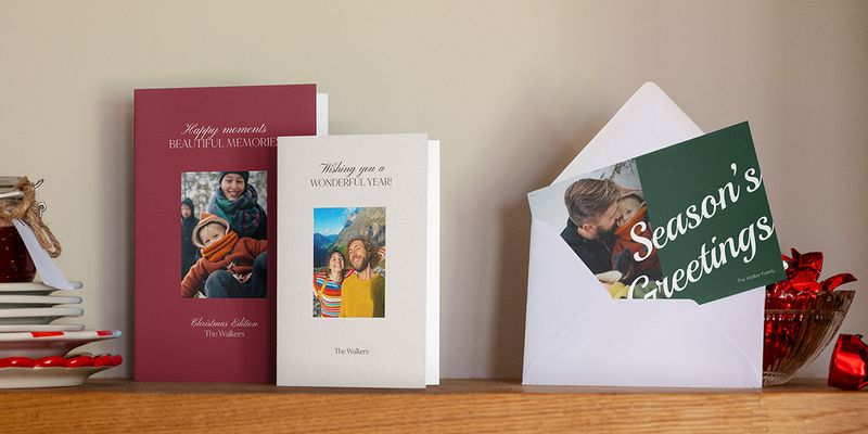Bordeauxrode, grijze en groene fotokaarten op een houten plank, een in een envelop