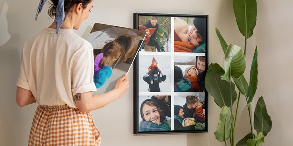 Gepersonaliseerde wanddecoratie ideeën, waarbij een vrouw een ingelijste fotocollage van familiefoto's bewondert.