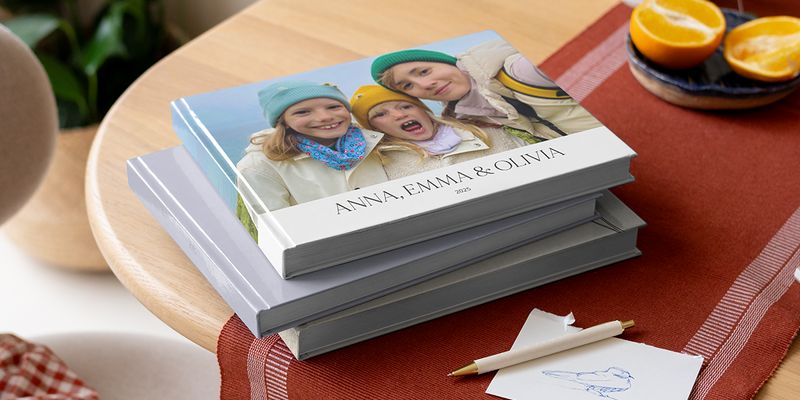 Een selectie fotoboeken van albelli met een pen, met broers en zussen op de omslag als inspiratie voor fotoboek quotes en wat te schrijven in een fotoalbum.