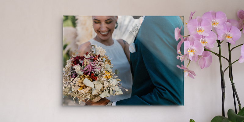 Bruiloft decoratie van albelli met een lachende bruid die een boeket vasthoudt, opgehangen aan de muur naast een orchidee.