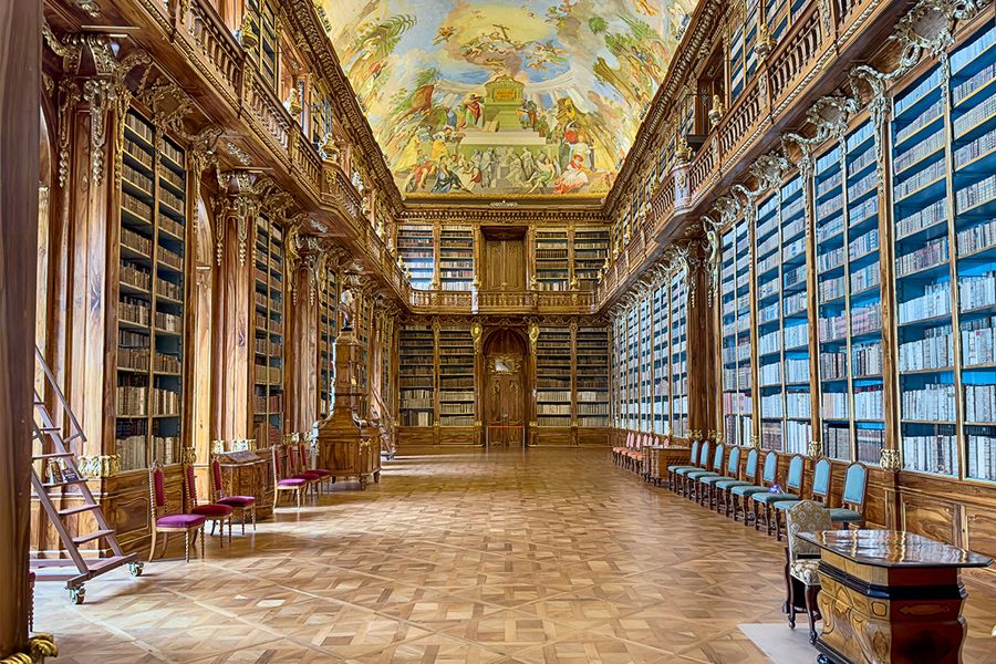 De Filosofische Zaal van de Strahov-kloosterbibliotheek in Praag, met hoge plafonds en notenhouten kasten, een topbestemming voor een literaire reis met albelli.