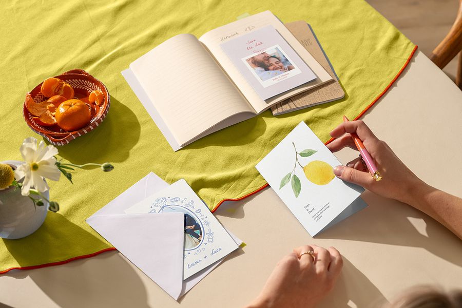 Een collectie trending trouwkaarten op een felgekleurd citrus tafelkleed, als voorbeeld van de trouwtrends voor 2026 en kleurrijke thema's voor de bruiloft bij albelli.