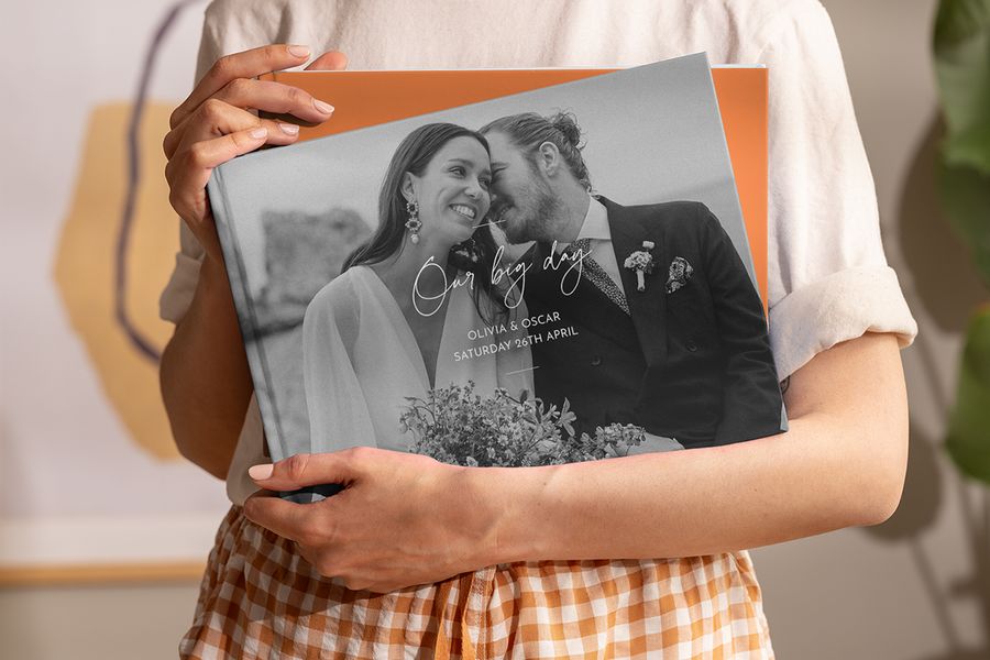 Een vrouw houdt een gepersonaliseerd albelli wedding koffietafelboek in haar handen, als inspiratie voor een wedding koffietafelboek en een gepersonaliseerd koffietafelboek.