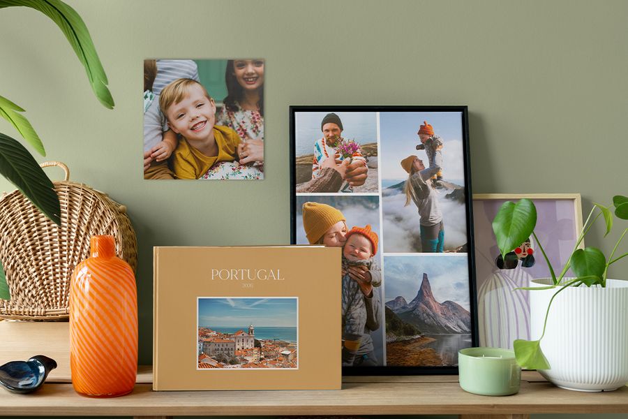 Een gepersonaliseerd reisfotoboek staat naast een ingelijste fotocollage en een familiefoto aan de muur, als inspiratie om je huis huiselijker te maken met betekenisvolle fotodecoratie.