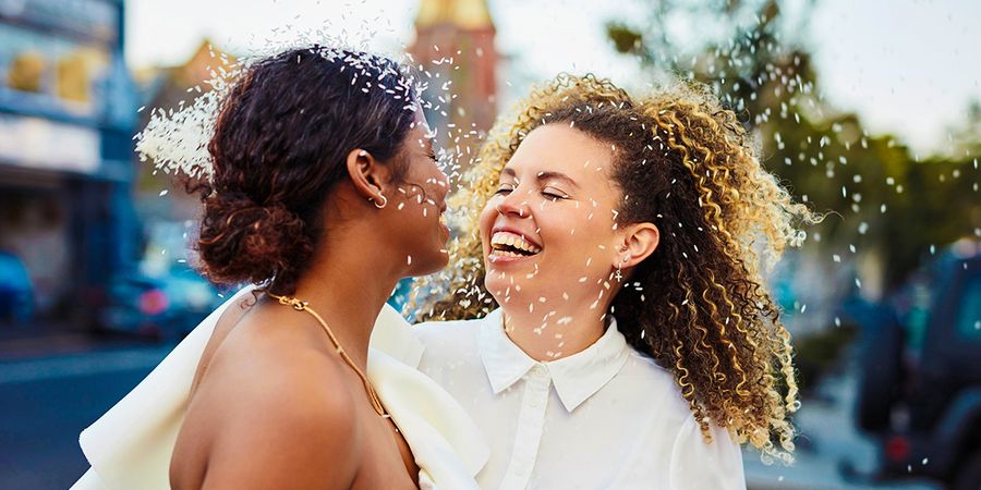 Een glimlachend bruidspaar op hun trouwdag, als inspiratie voor wat je in een trouwkaart schrijft en mooie tekst voor in een trouwkaart.