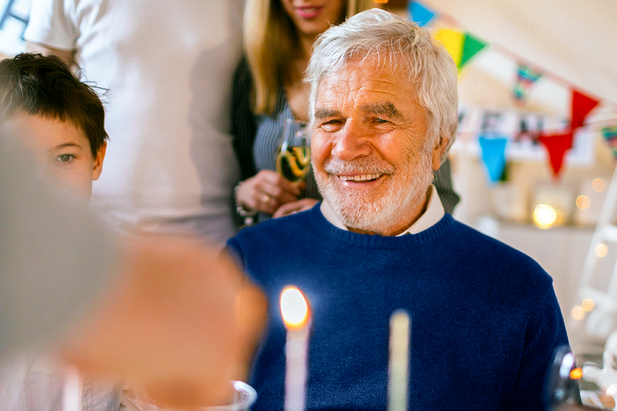 Een glimlachende opa op zijn verjaardagsfeest, een mooi voorbeeld van een verjaardagscadeau voor vader of een origineel verjaardagscadeau van albelli.