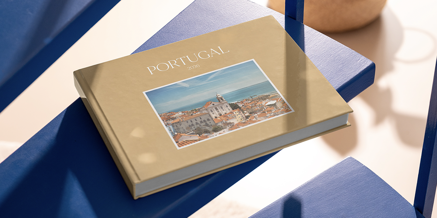 Een gepersonaliseerd albelli familiefotoboek met het label Portugal 2026 ligt op tafel en legt familiereisherinneringen vast als mooie manier om een vakantie met kinderen te herinneren.