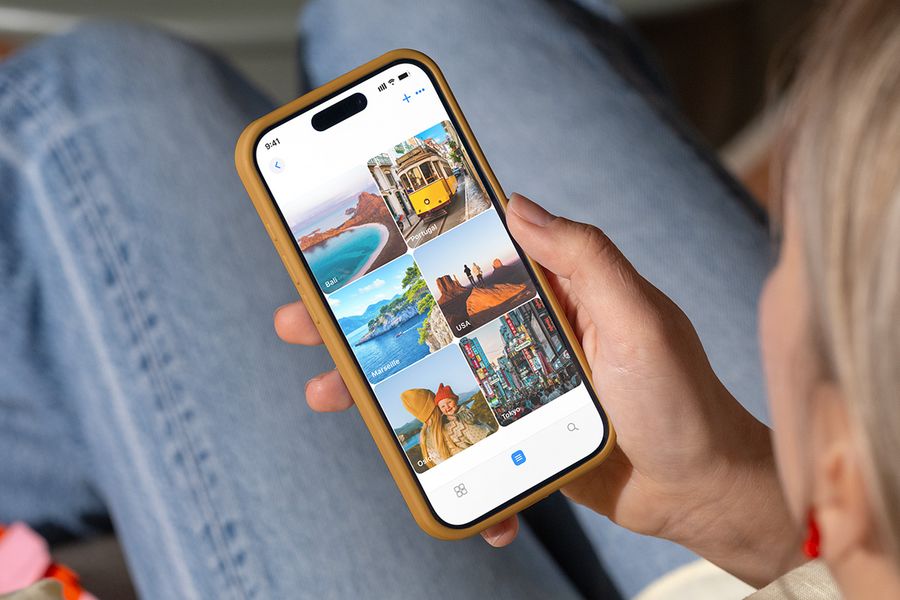 Iemand bekijkt fotomappen op zijn telefoon die zijn genoemd naar vakantiebestemmingen zoals 'Bali' en 'Tokyo', ter illustratie van albelli's tips om foto's te organiseren die klaar zijn om af te drukken.
