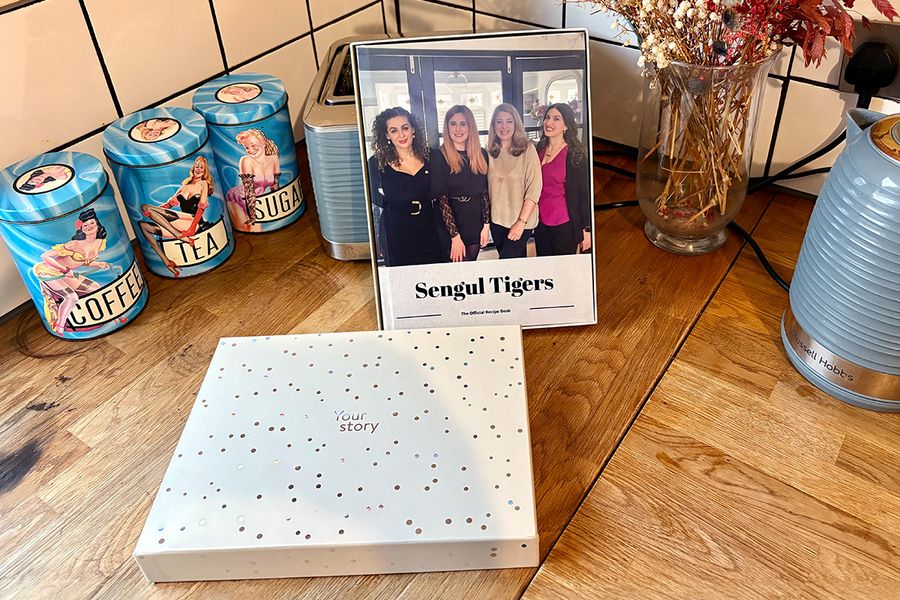 Sarah's gepersonaliseerde familiekookboek ligt in een albelli cadeaudoos, ter illustratie van hoe een gepersonaliseerd kookboek een attent cadeau is voor verjaardagen, jubilea en andere speciale gelegenheden.