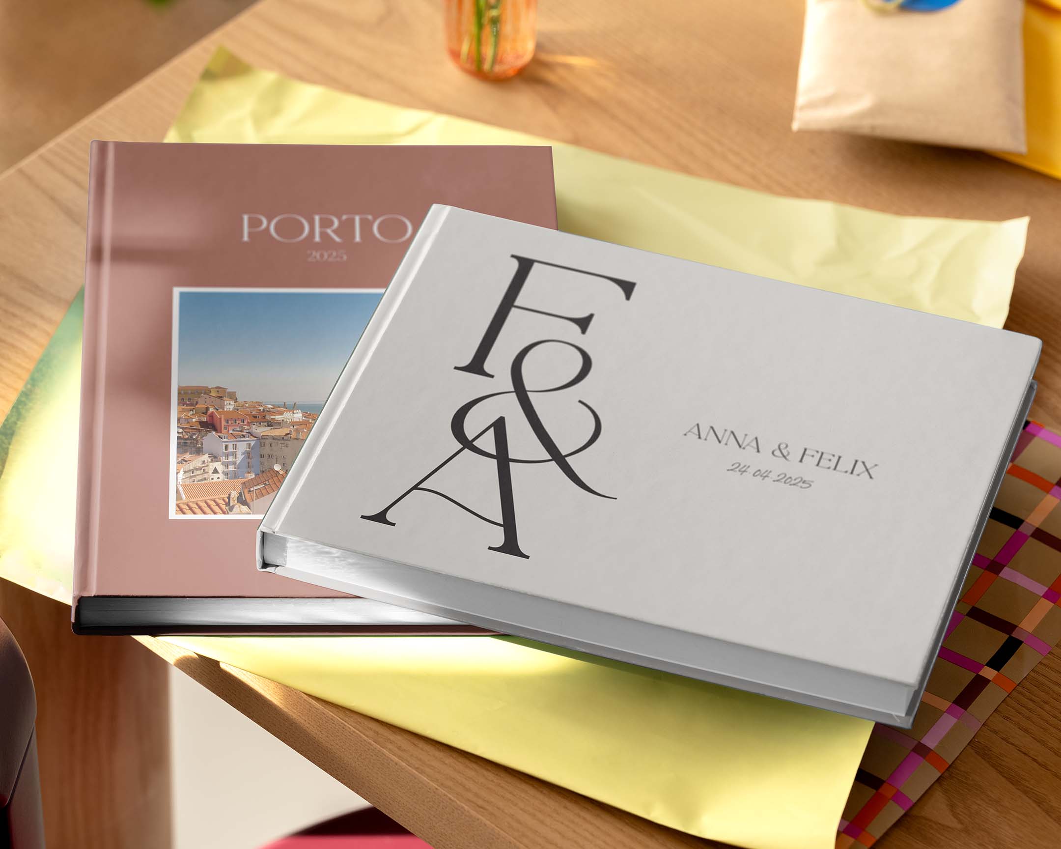 Twee gepersonaliseerde fotoboeken in verschillende formaten en ontwerpen op een tafel.
