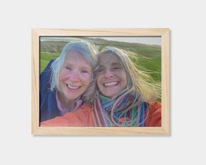 Een ingelijste poster met een foto van twee lachende vrouwen