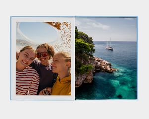 Een groot staand fotoboek met een foto van een persoon die naar een bergmeer kijkt