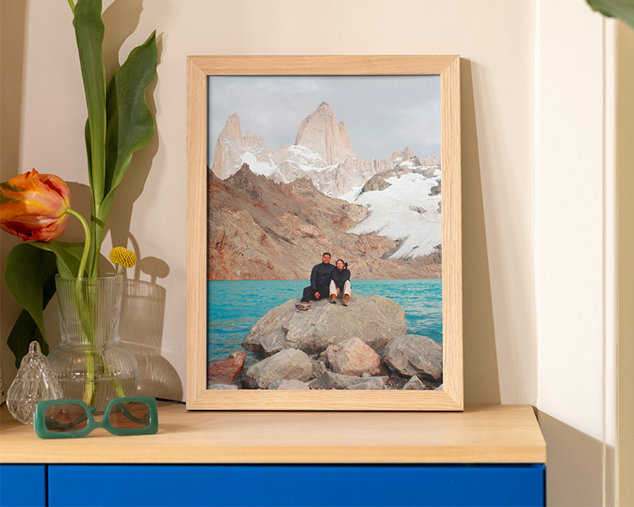 Een ingelijste landschapsfoto op een houten plank