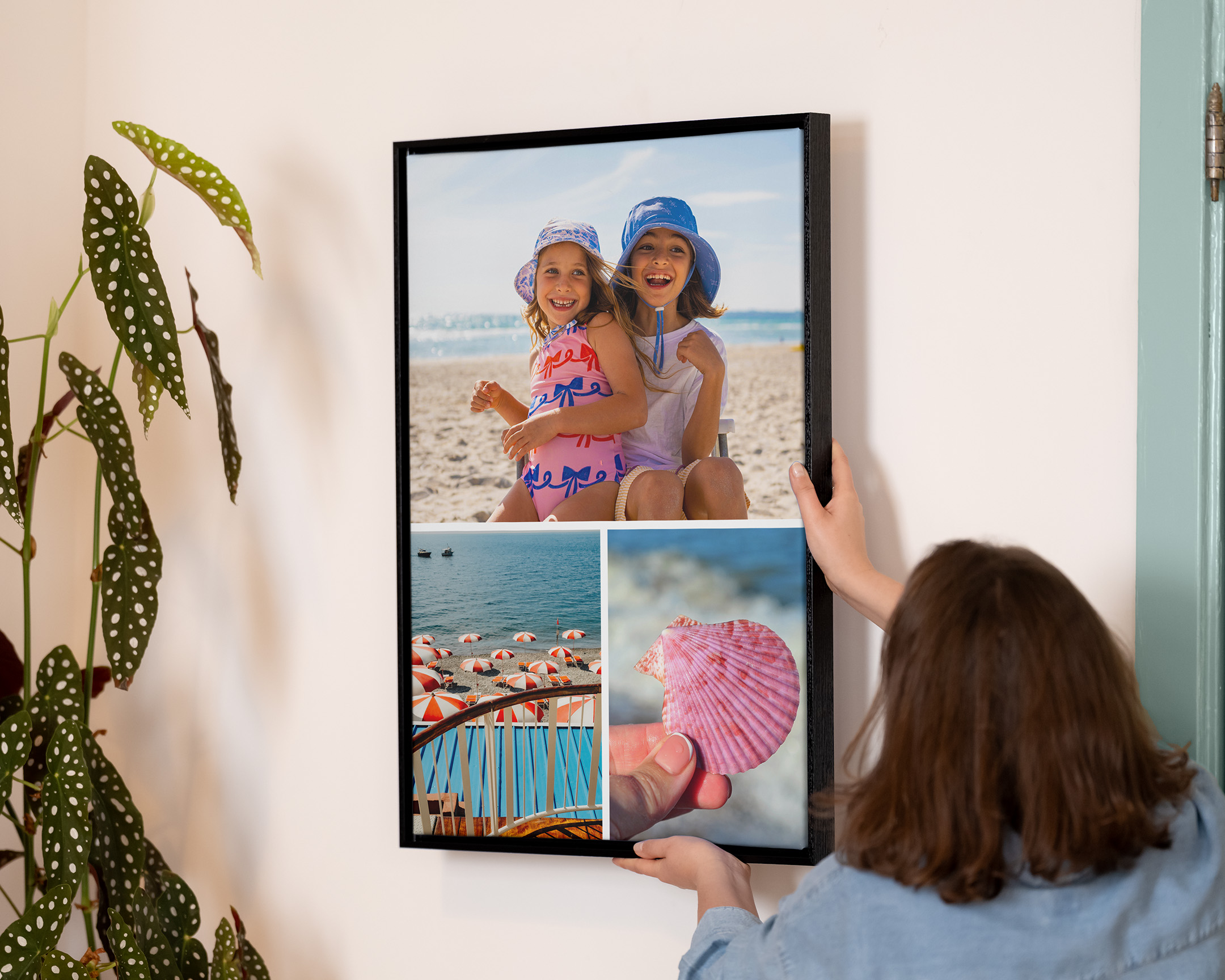 Persoon die een ingelijste collageprint ophangt