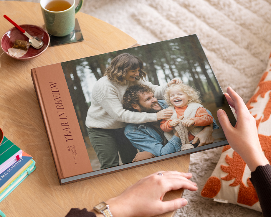 Een albelli koffietafelboek met een jaaroverzicht en een mooie familiefoto op de omslag, liggend op een salontafel als inspiratie voor een gepersonaliseerd koffietafelboek.