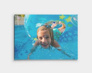 Foto op canvas met een kind dat onder water zwemt in een zwembad.